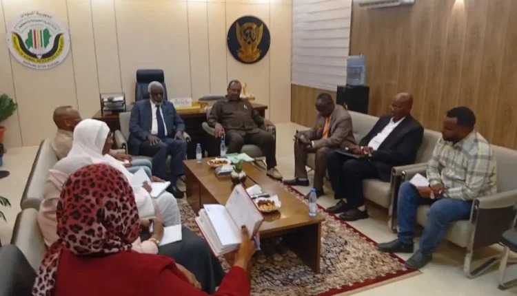 Officials and staff sit around a low table in an office during a meeting on livestock.