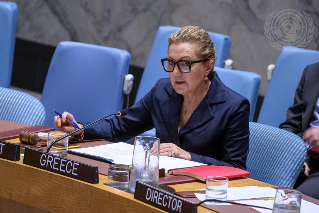 A delegate seated behind the Greece nameplate speaks into a microphone at the UN Security Council table.